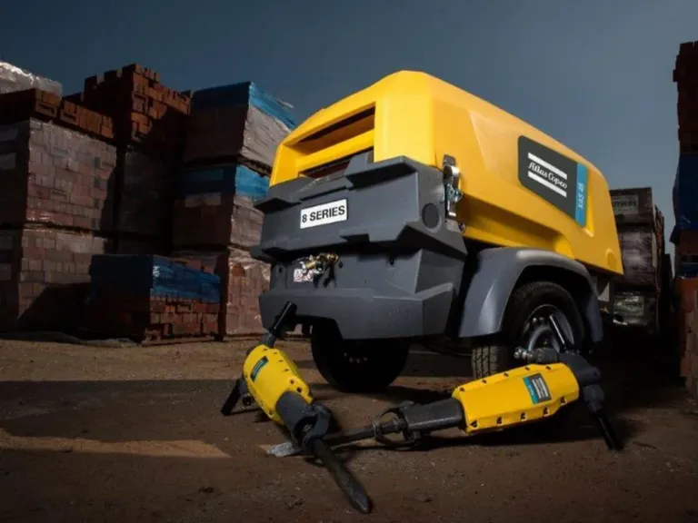 Mobil Atlas Copco-kompressor med luftverktøy på et anlegg