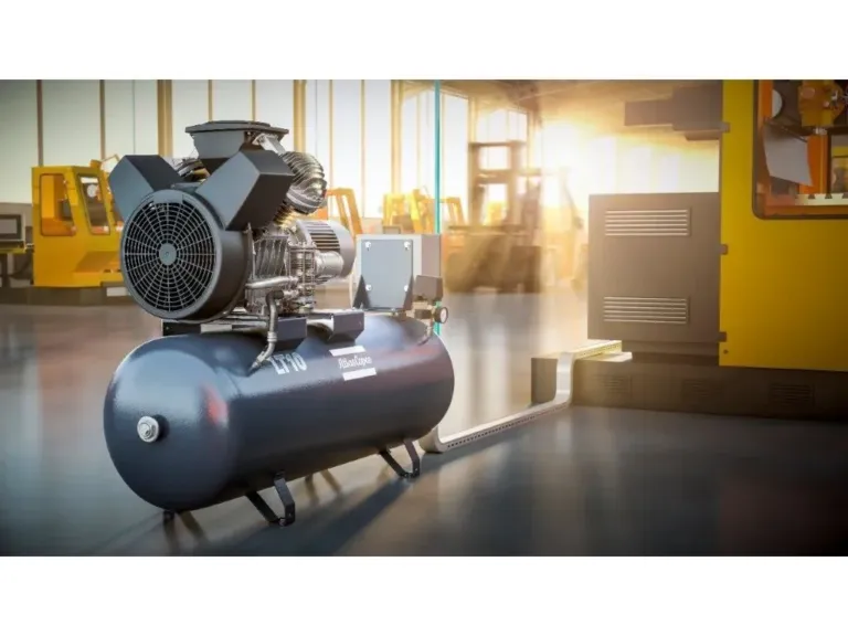Atlas Copco stempelkompressor med lufttank på et verkstedgulv